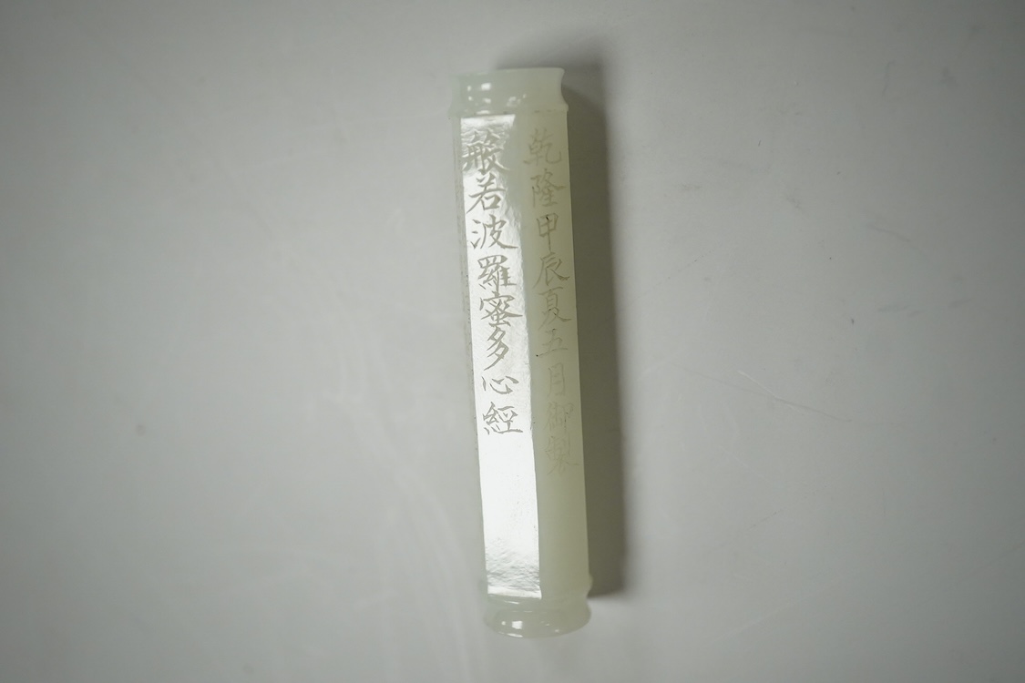 A Chinese pale celadon jade inscribed cylinder bead, 6.5cm long